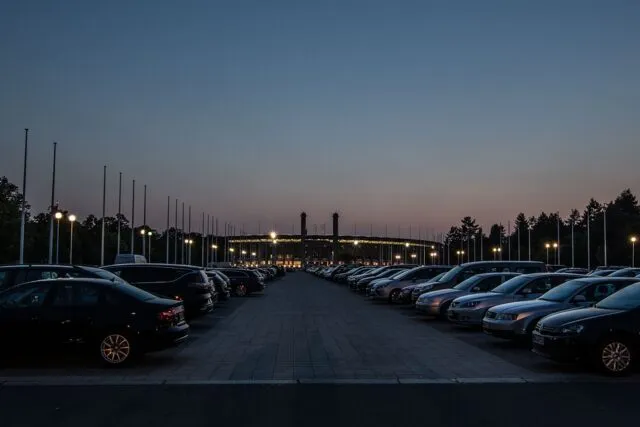 Tribună de stadion cu spectatori, în lumina reflectoarelor, la un meci de seară