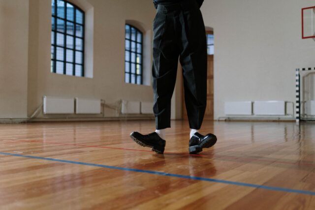 Pereche de pantofi de alergare pe podeaua unei săli de sport, pregătiți pentru reluarea antrenamentelor